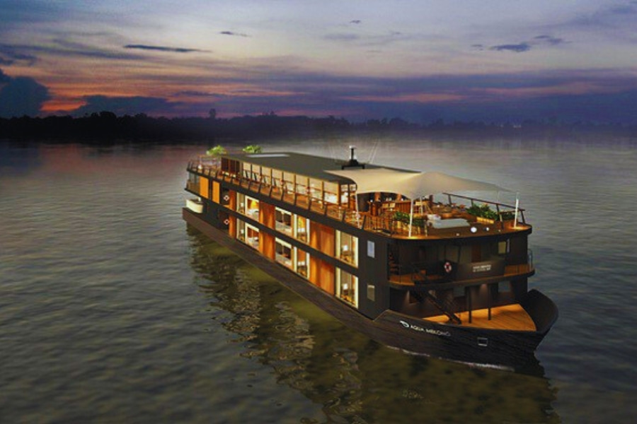 Aqua Mekong Luxury River Cruise glowing at night over calm waters by Auasia Travel